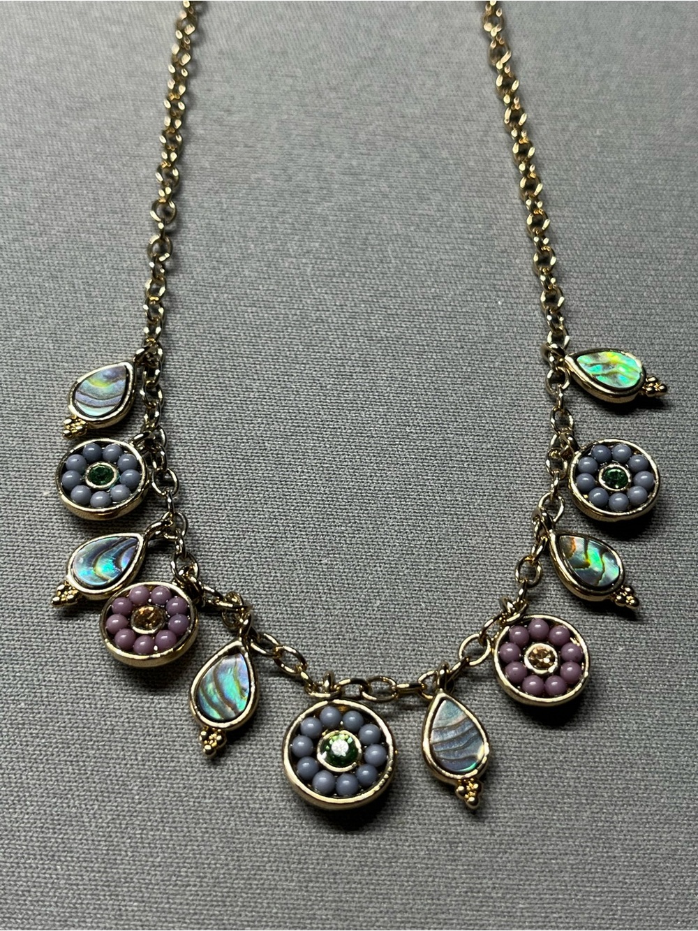 Gold tone vida jewels necklace w/dangling pendants. Chain is 16” long w/extender